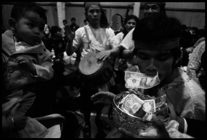 Cambodian New Year's celebration: musician using his mouth to put money into the bowl