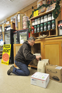 Rick Oliver stocking bags of coffee beans at the New Salem General Store