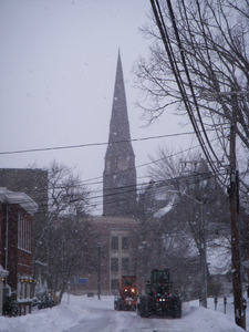 Snow plows on the street, Northampton, Mass., steeple of the First Church of Northampton in background