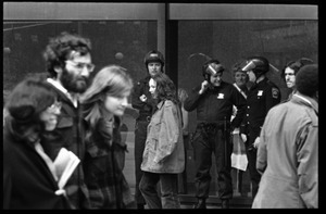 Police watch as antiwar demonstrators picket in front of the John F. Kennedy Federal Building