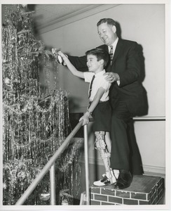 Willis C. Gorthy decorating Christmas tree with young client