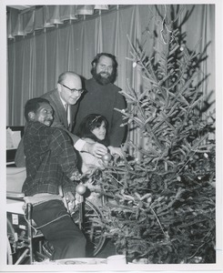 Dr. DiMichael and unidentified man decorating Christmas tree with clients