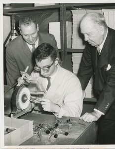 Leo Hausman and Jeremiah Milbank, Sr. watching Martin Suecof operate a buffing and polishing machine