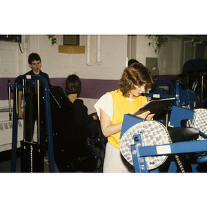 Woman looks at a clipboard in a gym