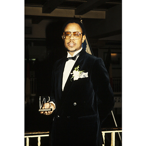 Man in formal dress holding an award