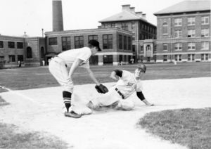 Suffolk University baseball player Fred Knox tries to avoid the tag as he slides into third base, 1961
