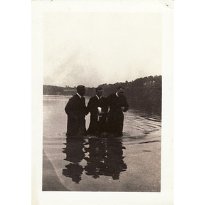 Reverend Dr. Wm. Frederick Fisher and two men prepare for a baptism