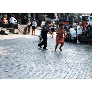 Man and woman shimmy and dance across the plaza during Festival Betances.