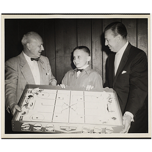 Arthur T. Burger, at left, and Boone Gross presenting an air hockey table to Michael Sarson at a Boys' Clubs of Boston Awards Night