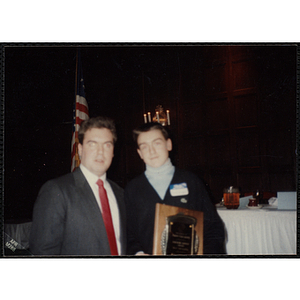 Jason Gallagher holding a plaque and posing with an unidentified man at the "Recognition Dinner at Harvard Club"