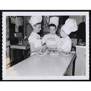 Two members of the Tom Pappas Chefs' Club shake hands in a kitchen