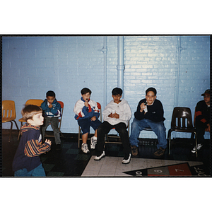 Several boys sitting and hanging out while at an open house