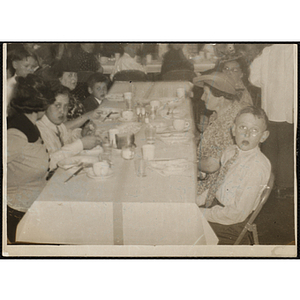 Women and boys sit a table during a dinner