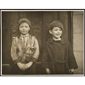 Two boys from the Boys' Clubs of Boston, wearing hats, posing in front of a door