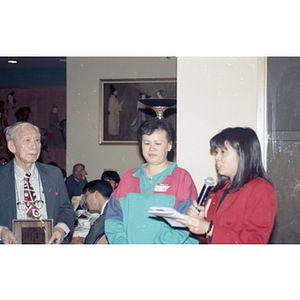 Award recipient stands next to two women at the Chinese Progressive Association's celebration of the Chinese New Year