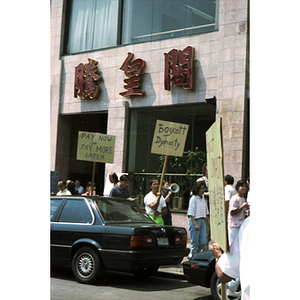 Demonstrators hold protest signs and picket for workers' back wages at Dynasty Restaurant