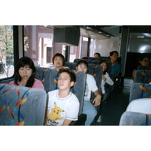 Chinese Progressive Association members sit together on a charter bus