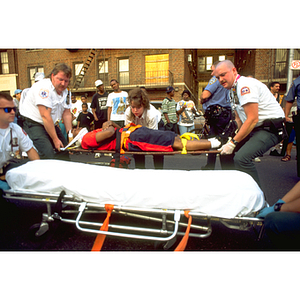 EMTs lift an injured man on a gurney