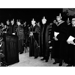 Faculty and administrators on stage during the commencement ceremony, 1965