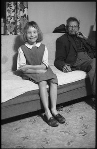 Peggy, daughter of Mildred and Richard Loving, seated on a couch with Richard's father