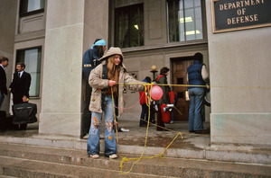 Young woman pulling thread across the steps of the Pentagon