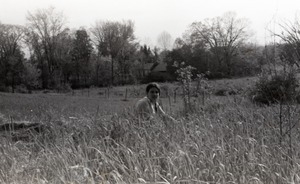 Young woman seated in tall grass