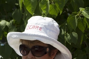 Pro-immigration protester wearing a sun hat with the words 'I care': taken at the 'Families Belong Together' protest against the Trump administration's immigration policies