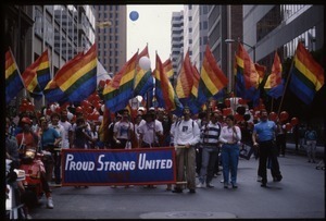 Group marching in the San Francisco Pride Parade with pride flags and banner reading 'Proud / strong / united 1987'