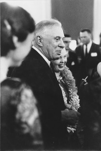 Louis M. Lyons standing indoors at a dinner