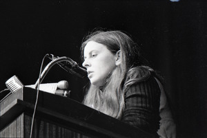 Bernadette Devlin McAliskey at the podium during a talk at Northeastern University