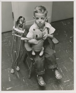 Young boy seated with stuffed animal