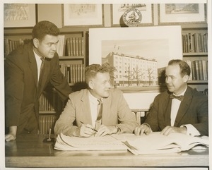 Willis C. Gorthy signing paperwork at a presentation of prospective building plans