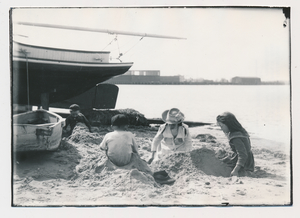 A Woman and Children play in the sand