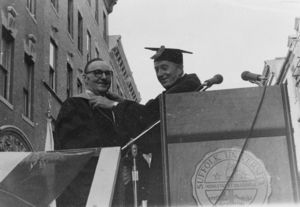 Outgoing Suffolk University President John E. Fenton (1965-1970) places the medallion of office on incoming President Thomas A. Fulhman at Fulham's presidential inauguration