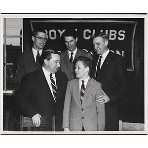 Senator John E. Powers and a boy smile at each other while three others look on from behind during a Boys' Clubs of Boston awards event