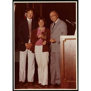Mary Ellen Doherty receives an award from Robert Cleary, Overseer of the Boys' Clubs of Boston, at right, and an unidentified man