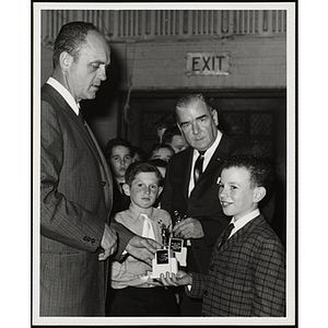 The Charlestown Kiwanis Club staffers present awards to two boys while others stand in a line behind them