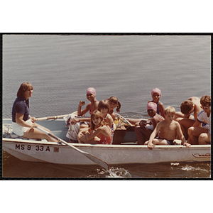 Children sit in a row boat with two adults
