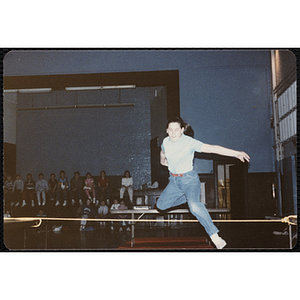 A girl jumps in the air over a rope at the Charlestown gymnasium