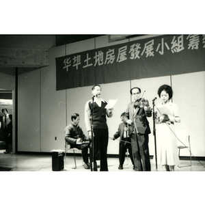 Singers accompany a band on stage at the Chinatown Task Force Fundraiser