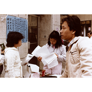 Community volunteers distribute handouts and collect signatures for Long Guang Huang at the corner of Beach Street and Harrison Avenue in Chinatown