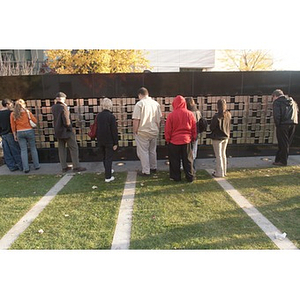 Several people look at the Veterans Memorial at the dedication ceremony