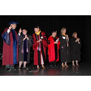 Faculty members stand onstage at School of Nursing convocation