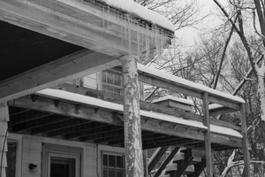 Icicles hanging from the eave of a house after a late-winter snow