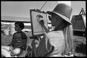 Artist drawing a sketch of a young boy at the Blandford Fair