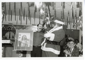 Man dressed as Santa Claus with unidentified staff member