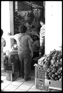 Customers speaking with a woman selling produce in the new marketplace, Belize City