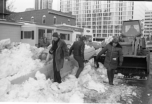 Pedestrians and construction equipment in front of car buried in snow on Cambridge Street