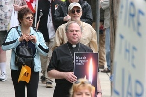 Priest in a crowd of anti-Iraq War protesters
