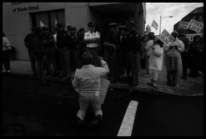 Pro-life protester on his knees, facing a line of police in front of the Providence Planned Parenthood clinic